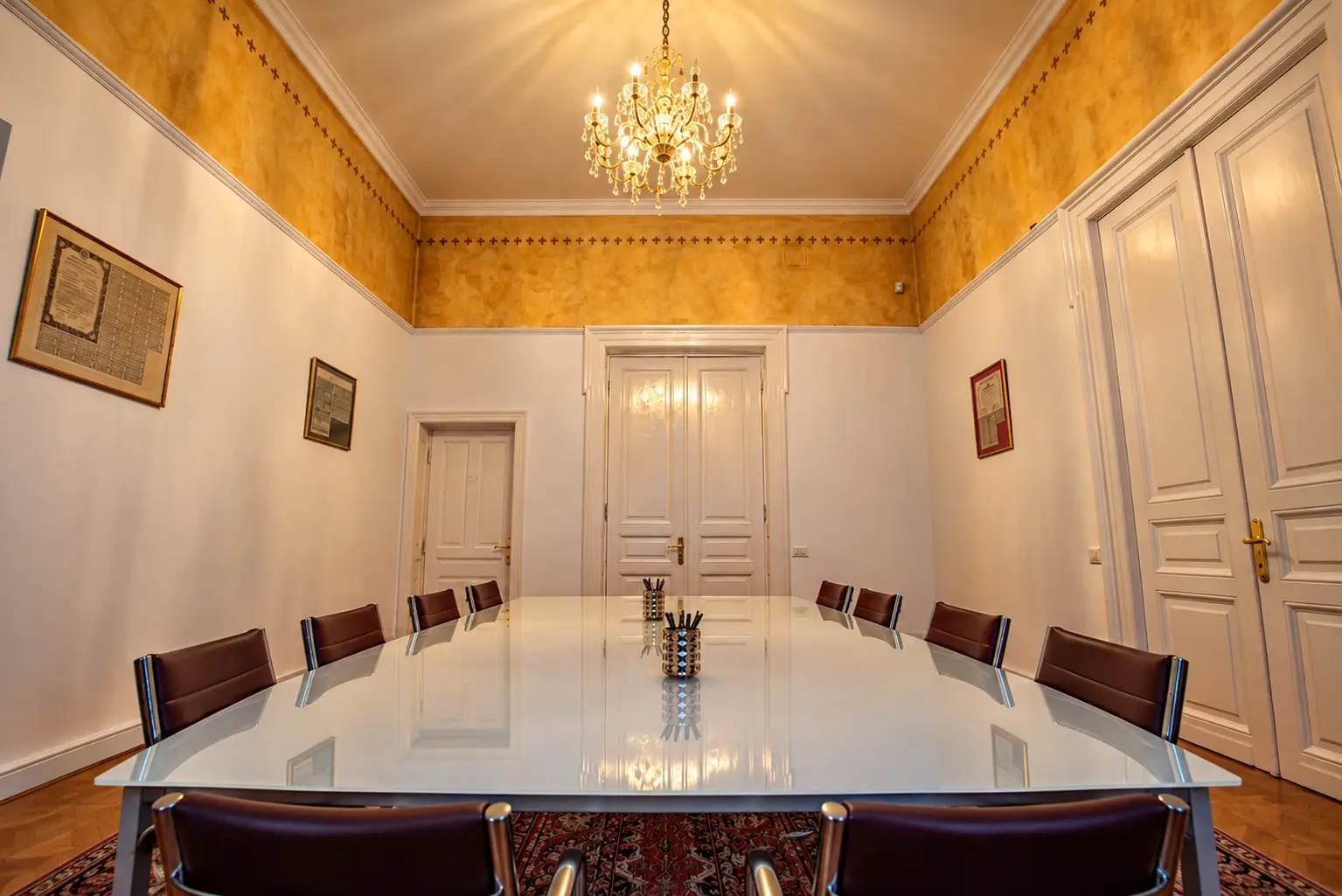 A conference room with golden walls and a chandelier