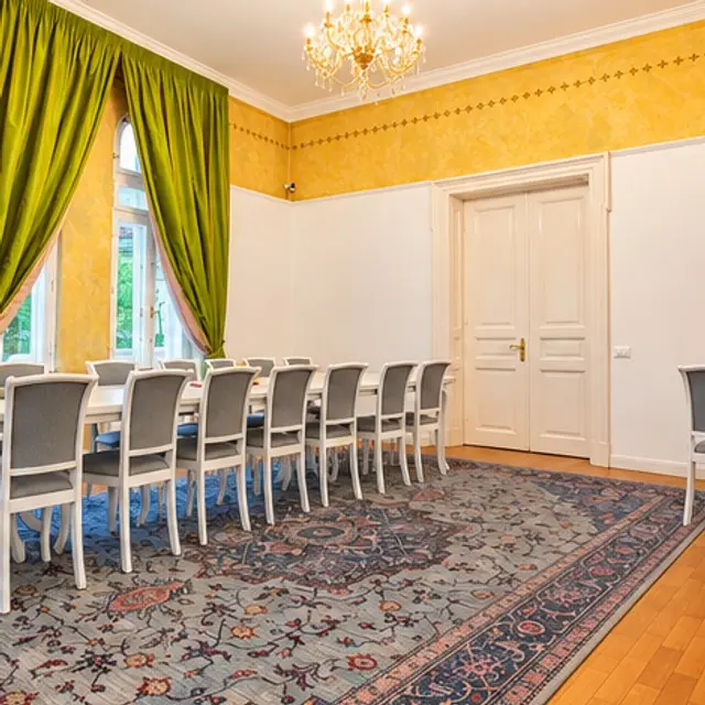Long table under green drapes and a chandelier